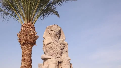 Ruins of the giant statue of pharoah with mountains in the background at Stock Footage 255587680