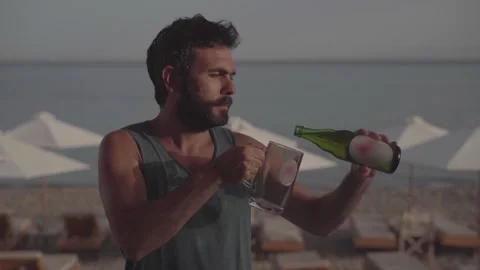 Rule breaker pours himself a cold beer on the beach despite local laws and Stock Footage 292960438