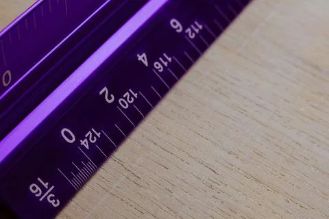 Ruler triangular in inches centimeters on white table Fotos Stock