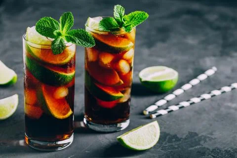 Rum and Cola Cuba Libre ice cold drink cocktail with lime and mint Stock Photos