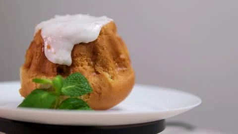 Rum baba cake, bun with white glaze Chinese pastry mooncake in the paper package Stock-Footage 295953862