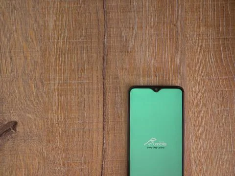 Rumble app launch screen with logo on the display of a black mobile smartphon Stock Photos