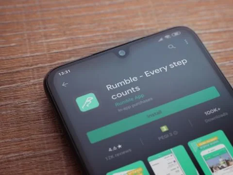 Rumble app play store page on the display of a black mobile smartphone on woo Stock Photos