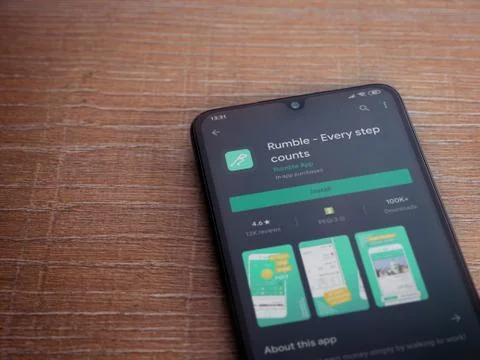 Rumble app play store page on the display of a black mobile smartphone on woo Stock Photos