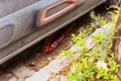 The rumpled destroyed red orange road plastic column under the car Stock Photos