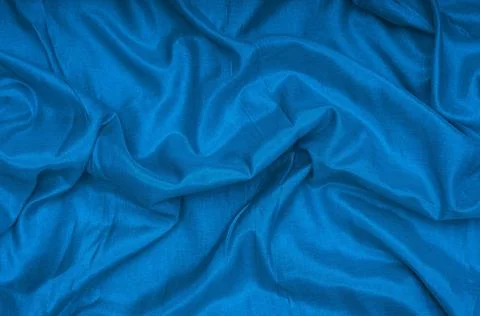Rumpled silk blue fabric texture. Classic blue background Stock Photos