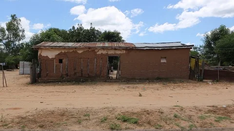 Run down adobe house with passing kid on bicycle Stock Footage 95496629