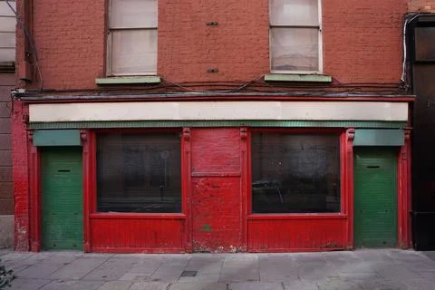 Run down old building with peeling paint and vacant shuttered store Stock Photos
