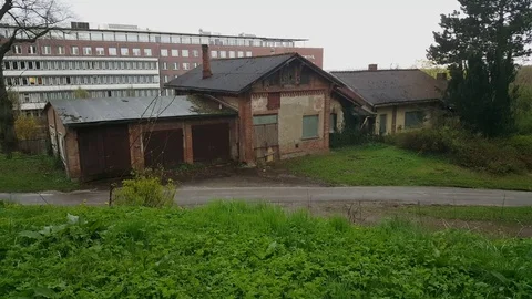 Run down old storage house in Schwerin cemetery, modern building in background 스톡 동영상 76303709