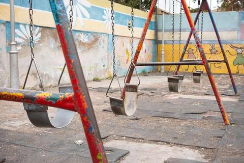 Run down swing on old children`s  playground Stock Photos