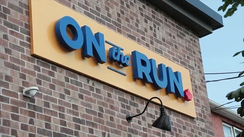 On the run writing caption text yellow blue sign on brick wall with light Stock Footage 250278716