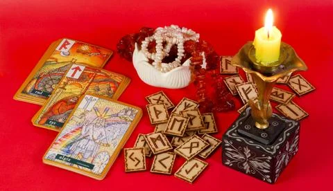 Rune divination against a backdrop of a candle and a rose flower Stock Photos