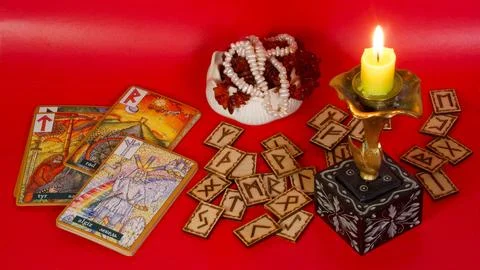 Rune divination against a backdrop of a candle and a rose flower Stock Photos