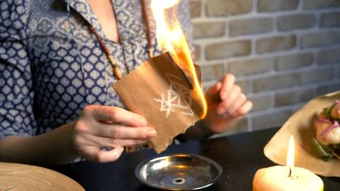 Runic magic. master burns runic spell on parchment 스톡 사진