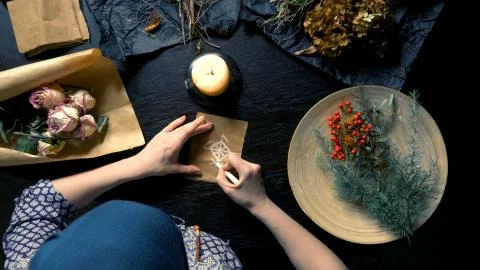 Runic magic. master writes runic spell on parchment Stock Photos