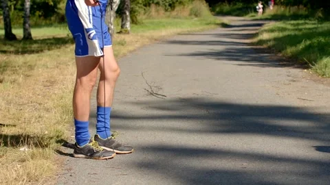 A runner accompanied by a dog is enjoying a bright summer day on a path Stock Footage 318926170