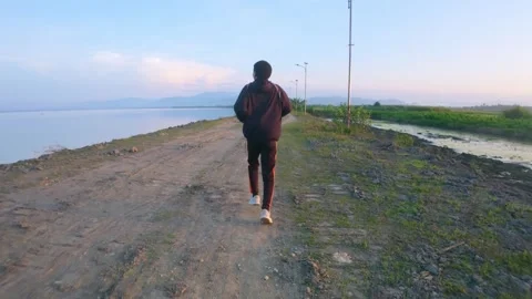 Runner Along River Path at Sunset Stock Footage 303765747