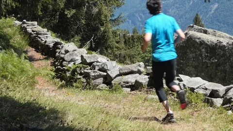 Runner on alpine trail with rocks Stock Footage 114175052