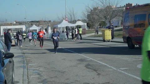 Runner approaching camera during urban 10K race Stock Footage 299004580