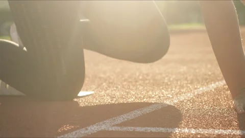 Runner assuming the starting position for a sprint race, handheld shot Stock Footage 245754265
