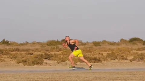 Runner athlete practising sprinting on dirt road on sunny day Video stock 132166068