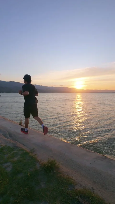 Runner athlete running on lakeside at beautiful sunset Video stock 300008645