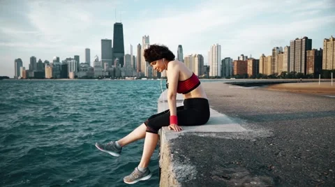 Runner athlete sitting and shaking feet at seaside Stock-Footage 67600904