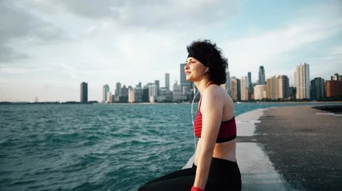 Runner athlete sitting and smiling at seaside Stock-Footage 67600797
