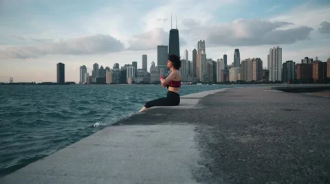 Runner athlete sitting on the background of skyscrapers and seaside Video stock 67403552
