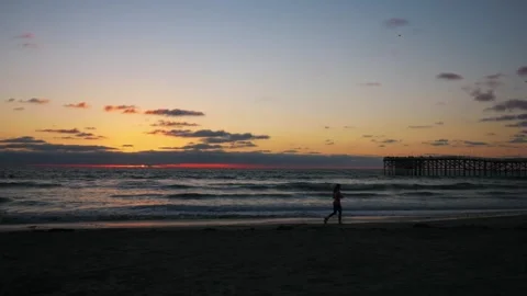 A runner on the beach during sunset in 4k Stock Footage 283462020