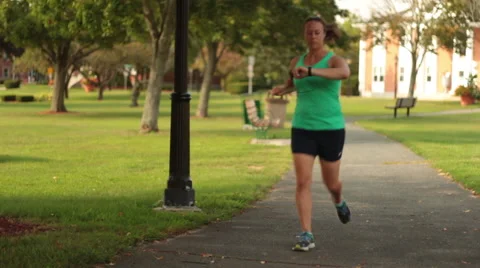 Runner Checking Fitness Band while Running Stock Footage 54406951