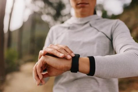 Runner checking fitness progress on her smart watch Stock Photos