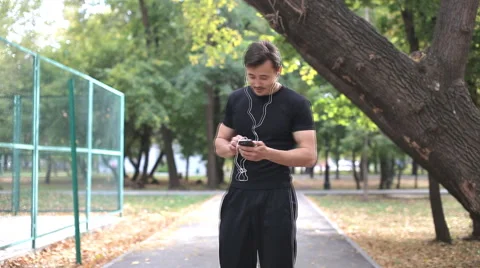 Runner  checks mail, writes reads sms, look in the phone Stock Footage 55707424