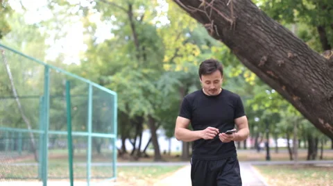 Runner checks mail, writes reads sms, look in the phone Stockbeeldmateriaal 55707987