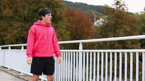 Runner in colored clothes crosses bridge in morning.athlete is tired of running Stock-Footage 253826840