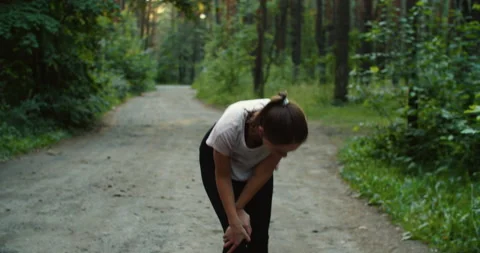 Runner complaining with knee ache after running in the woods Stock Footage 206824907