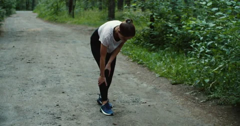 Runner complaining with knee ache after running in the woods Stock Footage 206993618