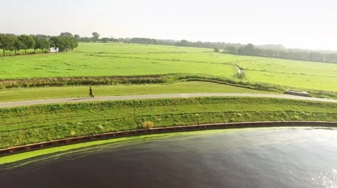 Runner on dike beside river. Typical Dutch landscape in the morning light. Video stock 66377860