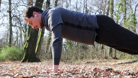 The runner is doing push-ups in the woods. Stock-Footage 228947069