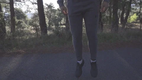 Runner doing warm up jumping in the forest Stock Footage 163748893