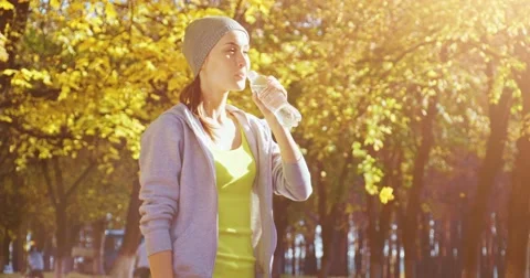 Runner Drinking Water in the sunny Autumn City. 4K DCi SLOW MOTION 120 FPS. Vídeo Stock 66767160