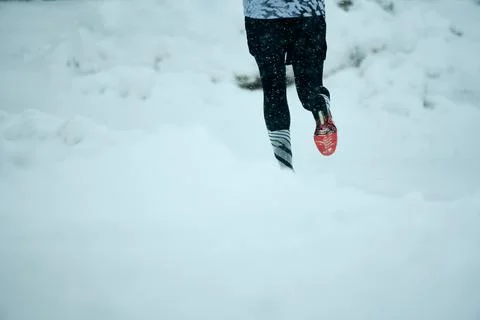 Runner exercises in fresh snow during a cold winter morning in a serene Stock Photos