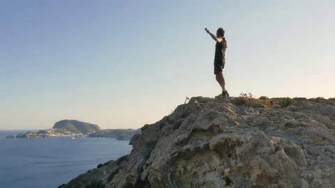 Runner exulting on top of a cliff on an island in front of the ocean Stock-Footage 80235059