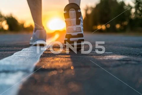 Runner feet running on road closeup Stock Photos