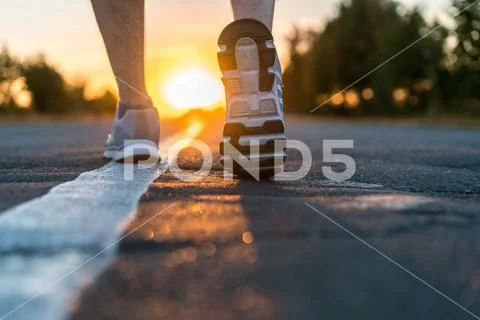 Runner feet running on road closeup Stock Photos