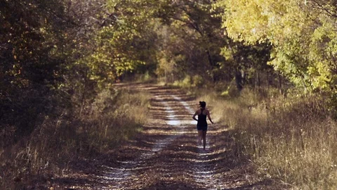 Runner female jogging training cross country autumn leaves falling Stock Footage 95875225