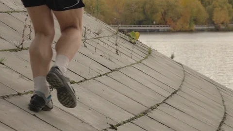 Runner on flagging downhill moving away from camera in slow motion. 動画素材 122154366