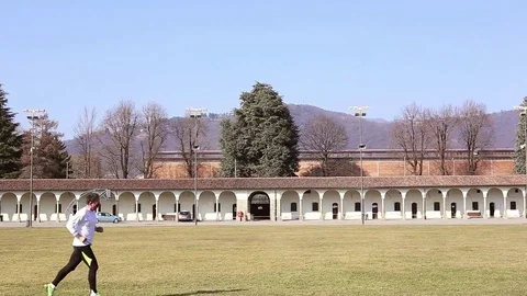 Runner in foreground in front of a Colonnade. left to right. Stock Footage 72954781
