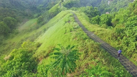 Runner on green hill walking road aerial Ubud Bali Stock Footage 98764526