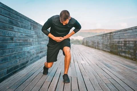 Runner having stomach side cramps or stitch during training. Pain in side Stock Photos